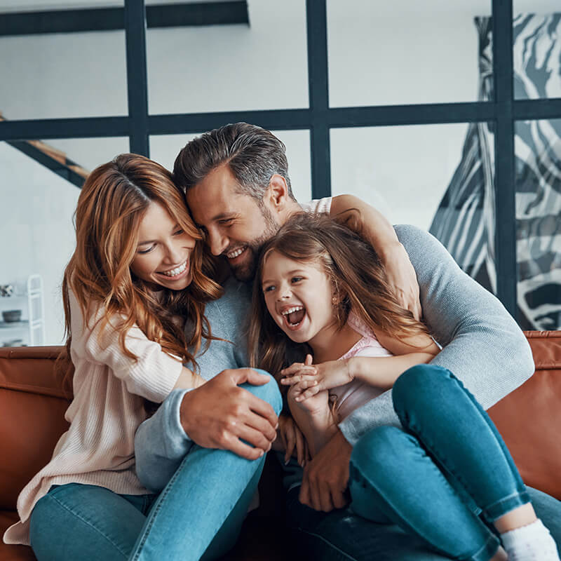 Family Smiling and Laughing on Couch