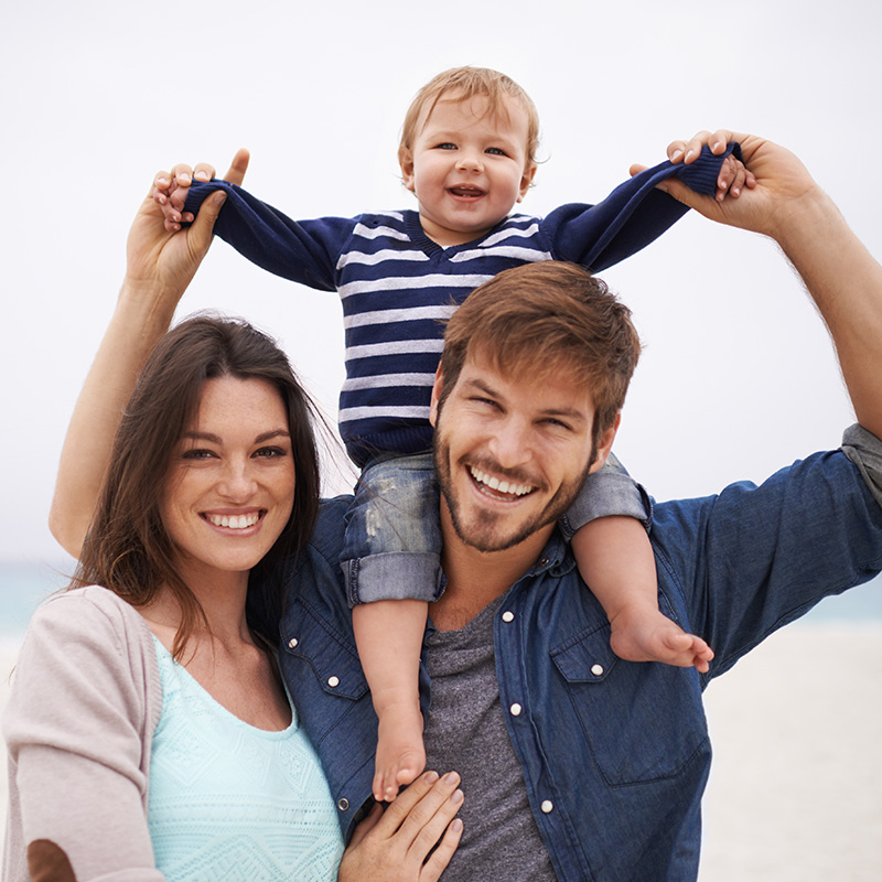 Mother, Father and Son on Beach Smiling